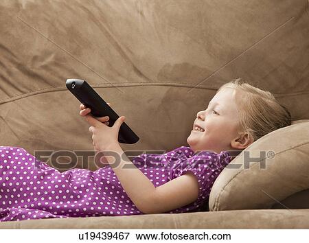 Stock Photo - Girl (2-3) watching TV on sofa. Fotosearch