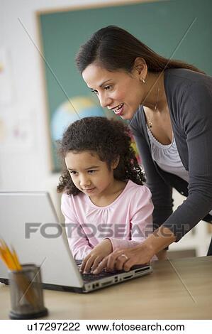 Girl (6-7) with female teacher using laptop in classroom View Large Photo Image Stock Image - Girl (6-7) with female teacher using laptop in classroom. Fotosearch