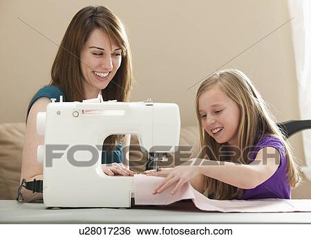 Girl (8-9) and young woman using sewing machine View Large Photo Image Stock Photograph - Girl (8-9) and young woman using sewing machine. Fotosearch