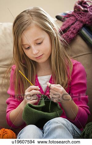 Picture - Girl (8-9) knitting woolly hat. Fotosearch