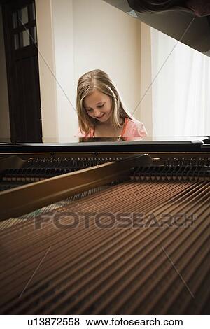 Girl (8-9) playing on grand piano View Large Photo Image Stock Photo - Girl (8-9) playing on grand piano. Fotosearch