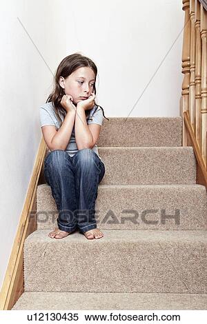 Stock Photography - Girl (8-9) sitting on stairs. Fotosearch