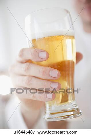 Hand holding glass of beer View Large Photo Image Stock Photo - Hand holding glass of beer. Fotosearch