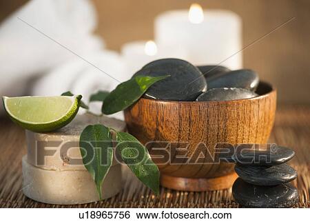Hot stones and slice of lime, candle in background View Large Photo Image Stock Photograph - Hot stones and slice of lime, candle in background. Fotosearch
