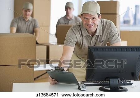 Stock Image - Man checking checklist in warehouse. Fotosearch
