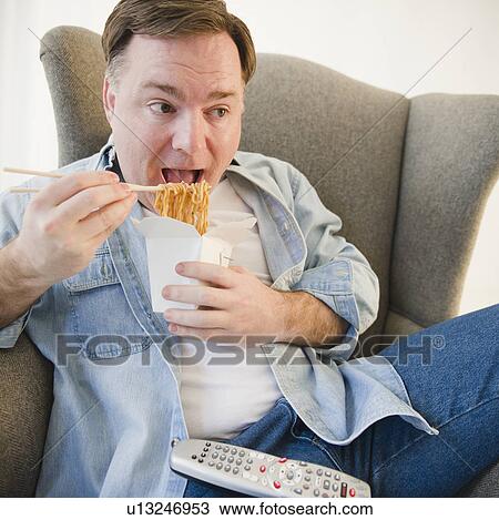 Stock Image - Man eating noodles. Fotosearch