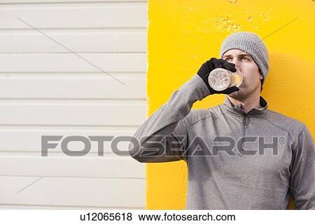 Man in workout wear drinking water View Large Photo Image Stock Photo - Man in workout wear drinking water. Fotosearch