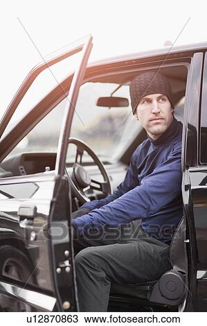 Stock Image - Man in workout wear getting out of truck. Fotosearch