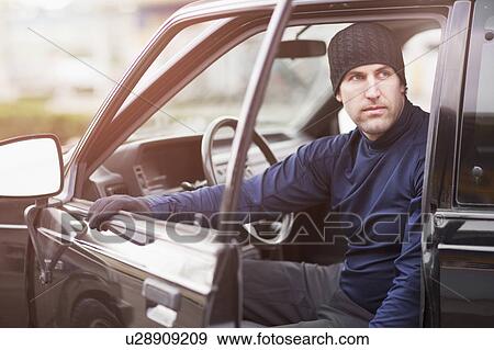 Stock Photo - Man in workout wear getting out of truck. Fotosearch