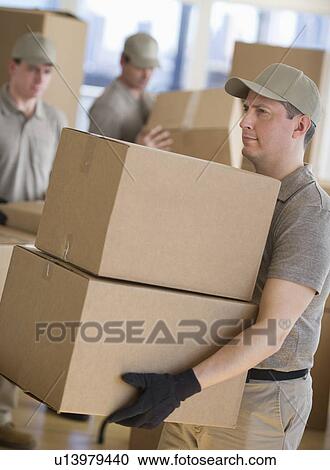 Stock Image - Men sorting boxes in warehouse. Fotosearch