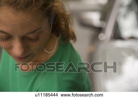 Picture - Mid adult woman listening to music. Fotosearch