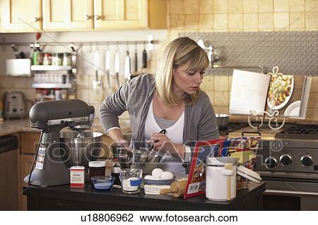 Stock Image - Mid adult woman making cake. Fotosearch
