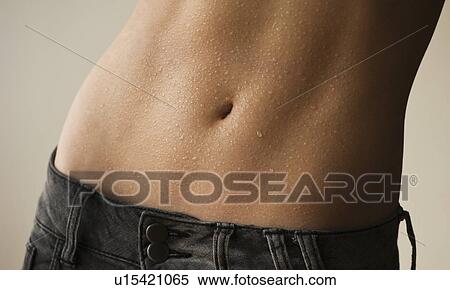 Stock Photography - Mid section of woman showing navel. Fotosearch