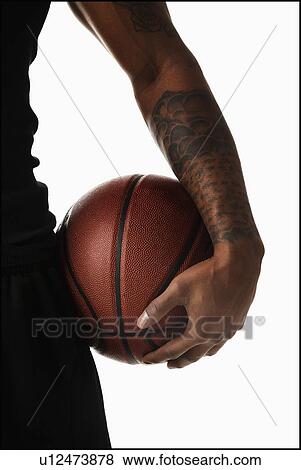 Midsection of tattooed man hooding basketball View Large Photo Image Stock Photo - Midsection of tattooed man hooding basketball. Fotosearch