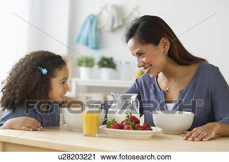 Stock Image - Mother and daughter (6-7) during breakfast. Fotosearch
