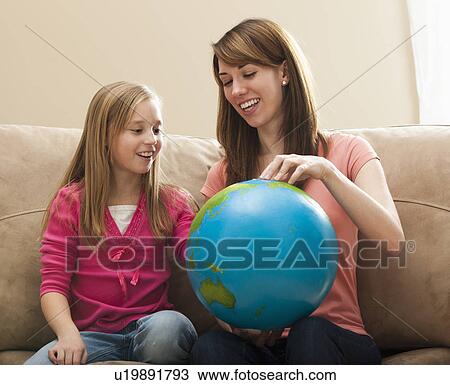 Mother and daughter (8-9) playing with globe View Large Photo Image Stock Image - Mother and daughter (8-9) playing with globe. Fotosearch