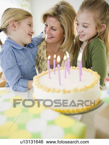 Mother and daughters (8-11) celebrating birthday View Large Photo Image Stock Photograph - Mother and daughters (8-11) celebrating birthday. Fotosearch