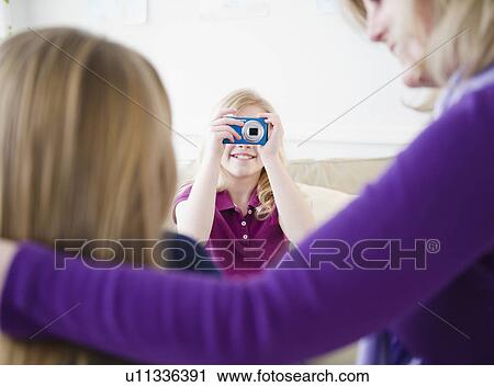 Stock Image - Mother and daughters (8-11) taking pictures. Fotosearch