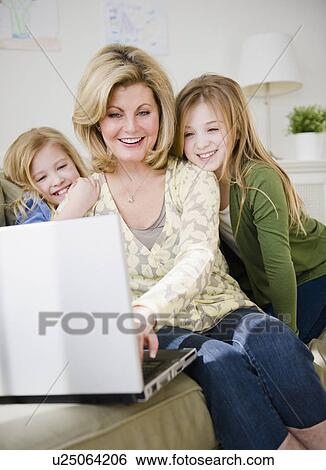 Mother and daughters (8-11) using laptop View Large Photo Image Stock Photograph - Mother and daughters (8-11) using laptop. Fotosearch