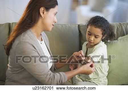 Mother applying band aid on daughter's (6-7) arm View Large Photo Image Stock Image - Mother applying band aid on daughter's (6-7) arm. Fotosearch