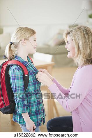 Mother buttoning daughter's (8-9) shirt View Large Photo Image Stock Image - Mother buttoning daughter's (8-9) shirt. Fotosearch
