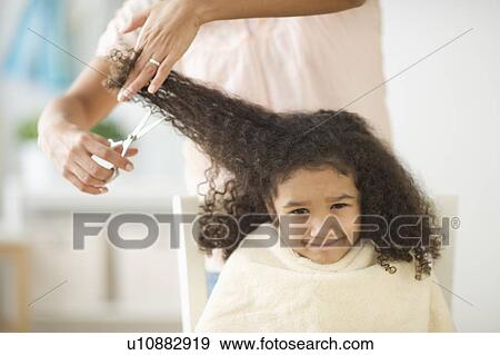 Stock Photo - Mother cutting daughter's (6-7) hair. Fotosearch