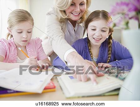 Mother helping daughters (8-11) with homework View Large Photo Image Stock Photography - Mother helping daughters (8-11) with homework. Fotosearch
