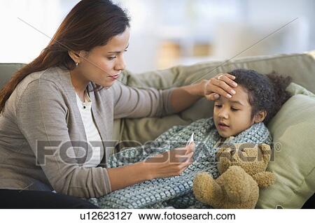 Stock Photo - Mother taking daughter's (6-7) temperature. Fotosearch