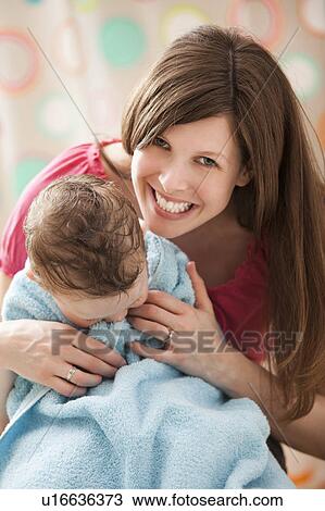 Stock Image - Mother with son (2-3) wrapped in towel. Fotosearch