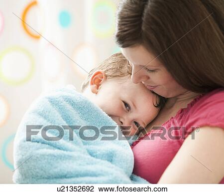 Stock Image - Mother with son (2-3) wrapped in towel. Fotosearch