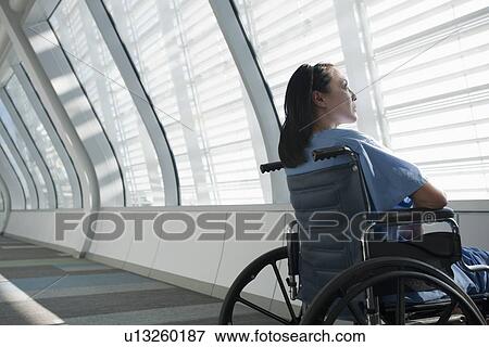 Stock Photo - Patient in wheelchair looking out window. Fotosearch