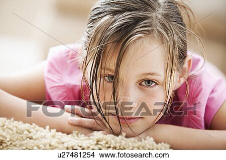 Picture - Portrait of girl (10-11) lying on floor. Fotosearch