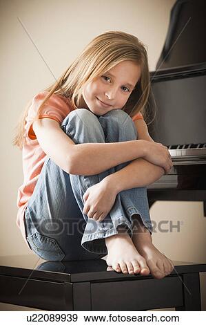 Portrait of girl (8-9) sitting by piano View Large Photo Image Stock Photo - Portrait of girl (8-9) sitting by piano. Fotosearch