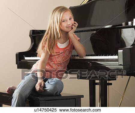 Portrait of girl (8-9) sitting by piano View Large Photo Image Stock Photography - Portrait of girl (8-9) sitting by piano. Fotosearch