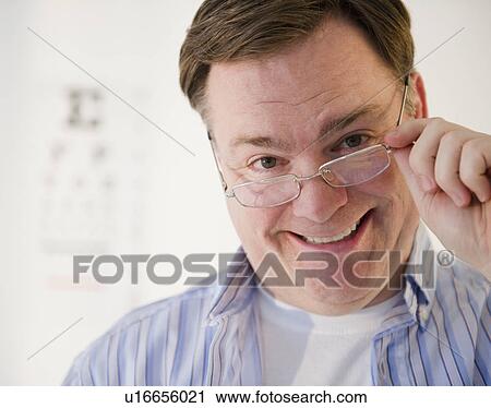 Portrait of man lowering glasses View Large Photo Image Stock Image - Portrait of man lowering glasses. Fotosearch