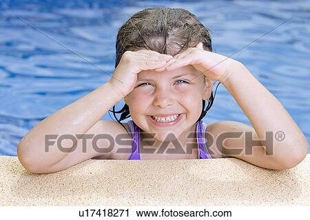 Stock Image - Portrait of smiling girl (6-7) in swimming pool. Fotosearch