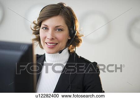 Portrait of smiling woman with headset in customer service office View Large Photo Image Stock Image - Portrait of smiling woman with headset in customer service office. Fotosearch