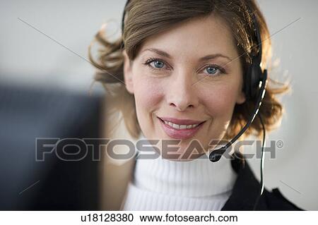 Portrait of smiling woman with headset in customer service office View Large Photo Image Stock Image - Portrait of smiling woman with headset in customer service office. Fotosearch