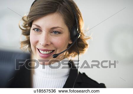 Portrait of smiling woman with headset in customer service office View Large Photo Image Stock Photograph - Portrait of smiling woman with headset in customer service office. Fotosearch