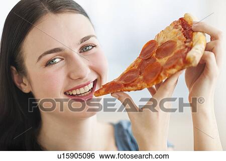 Portrait of smiling young woman eating pizza View Large Photo Image Stock Photograph - Portrait of smiling young woman eating pizza. Fotosearch