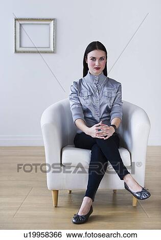 Stock Photograph - Portrait of woman sitting in armchair. Fotosearch
