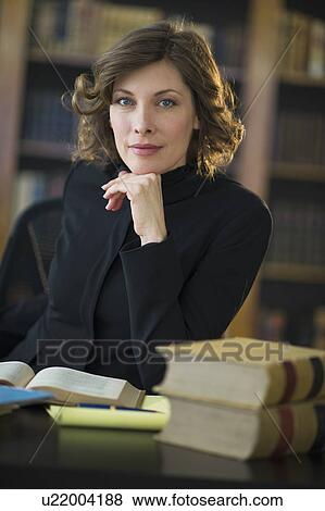 Stock Photo - Portrait of woman studying in library. Fotosearch