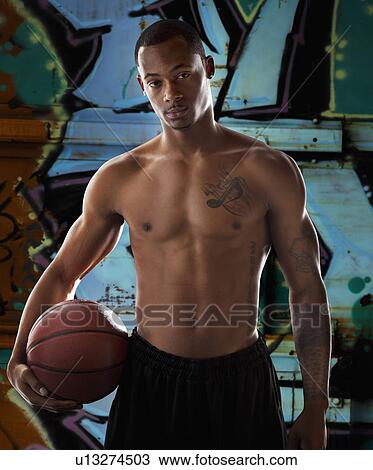 Stock Image - Portrait of young man with basketball. Fotosearch