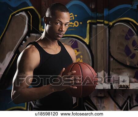 Stock Image - Portrait of young man with basketball. Fotosearch