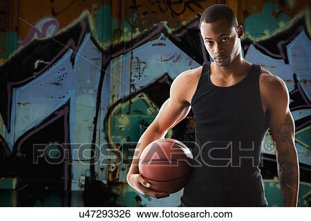 Stock Photograph - Portrait of young man with basketball. Fotosearch