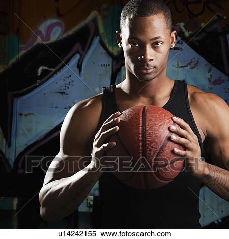 Stock Photography - Portrait of young man with basketball. Fotosearch