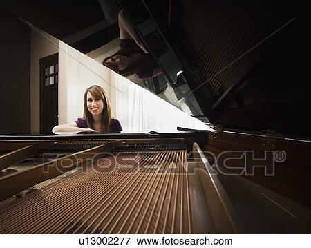 Portrait of young pianist sitting by grand piano View Large Photo Image Stock Photo - Portrait of young pianist sitting by grand piano. Fotosearch