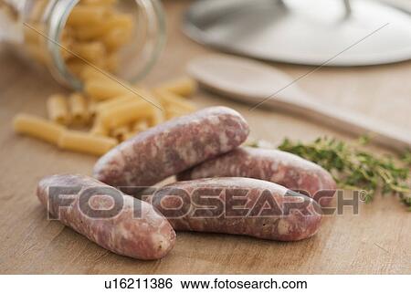 Raw sausage and pasta on kitchen table View Large Photo Image Stock Photograph - Raw sausage and pasta on kitchen table. Fotosearch