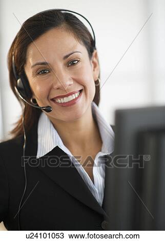 Stock Image - Smiling female customer service representative with headset. Fotosearch