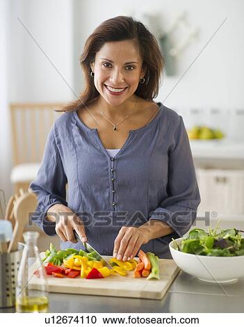 Smiling woman preparing food in kitchen View Large Photo Image Stock Image - Smiling woman preparing food in kitchen. Fotosearch